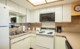 a kitchen with white cabinets and appliances , including a stove , oven , microwave , and coffee maker at Legacy Vacation Resorts-Indian Shores