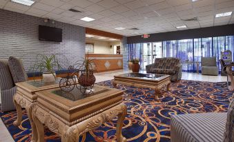 a hotel lobby with two couches , one on the left and one on the right at Ramada by Wyndham Cocoa