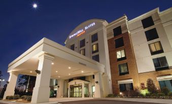 "a large , white hotel building with a sign that reads "" sheridan suites "" in the evening" at SpringHill Suites Athens West