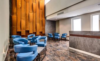 a modern hotel lobby with blue chairs and a wooden wall , creating a welcoming atmosphere at The District Hotel