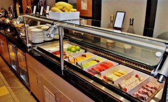 a buffet - style dining area with a variety of food items , including fruits , vegetables , and desserts at Hilton Alexandria Mark Center