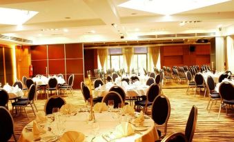 a large banquet hall filled with round tables and chairs , ready for a formal event at Radisson Blu Hotel, Bamako