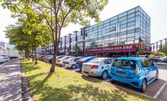 There is a parking lot in front with cars parked and an office building located behind it at De Elements Business Hotel KL