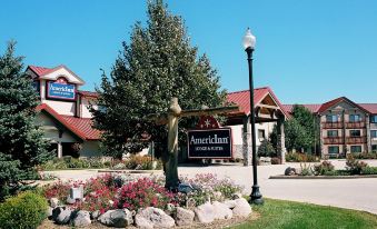 "a hotel with a sign that reads "" american lodge & suites "" in front of it" at AmericInn by Wyndham Oswego