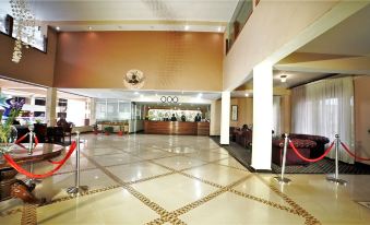 a large hotel lobby with marble floors and a reception desk , where people are waiting to enter at Silver Springs Hotel