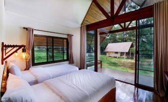 a room with two beds , one on each side of the room , and a bathroom in the background at Phayamas Private Beach Resort and Island Brew - Adults Only