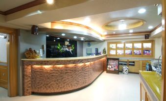 a hotel lobby with a large reception desk and several chairs arranged around it , providing seating for guests at Laurel Hotel