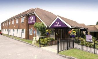 a hotel with a purple sign on the side of the building , located in a residential area at Premier Inn Tring