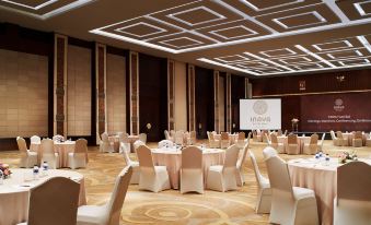 a large , well - lit conference room with multiple tables and chairs set up for an event at Merusaka Nusa Dua