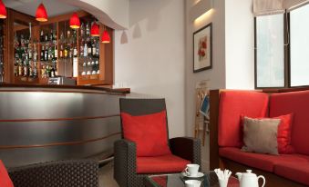 a cozy living room with a bar , two couches , and a coffee table filled with cups and saucers at Ibis Styles Paris Mairie de Montreuil