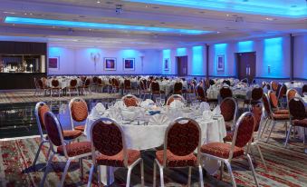 a large dining room with multiple tables and chairs set up for a formal event , possibly a wedding reception at Leonardo Hotel Middlesbrough