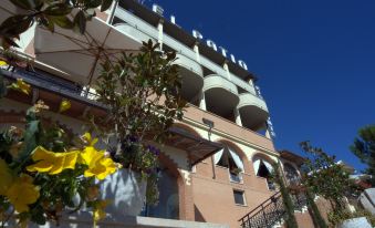 "a large building with a sign that reads "" casa del lujo "" is surrounded by greenery and flowers" at El Patio Hotel