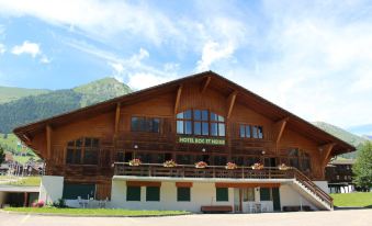 a large wooden building with multiple floors , possibly a hotel or a restaurant , situated in a mountainous area at Hotel Roc et Neige