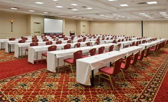 a large conference room with multiple rows of chairs arranged in a semicircle , and a projector on the wall at Doubletree by Hilton Columbus Dublin