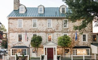 a brick building with multiple flags flying outside , creating a festive atmosphere for an outdoor event at The Red Fox Inn & Tavern