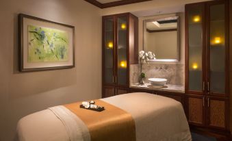 a massage room with a massage table and a sink in the background , creating a spa - like atmosphere at The Ritz-Carlton, Marina del Rey