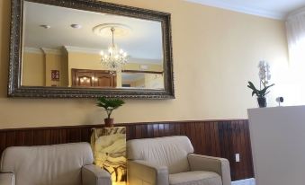 a living room with two couches , a lamp , and a mirror hanging on the wall at La Palmera Rooms