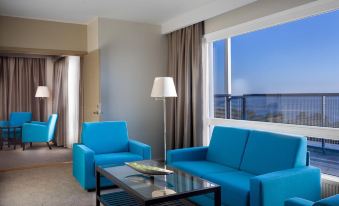 a modern living room with blue couches , a glass coffee table , and large windows offering views of the city at LaSpa