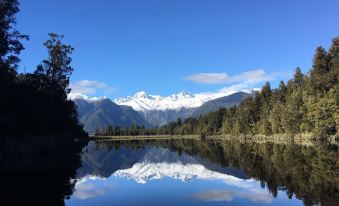 a serene landscape with a mountain range in the background and a calm lake reflecting its reflection at Sunset Motel