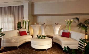 a room with three white couches and a table , creating a cozy and inviting atmosphere at Holiday Inn Laval - Montreal