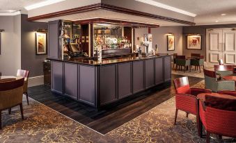 a bar with a long counter and chairs , surrounded by paintings on the wall and paintings on the ceiling at Mercure Bradford Bankfield Hotel