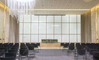 an empty conference room with rows of black chairs and a large window at the front at Holiday Inn Algiers - Cheraga Tower