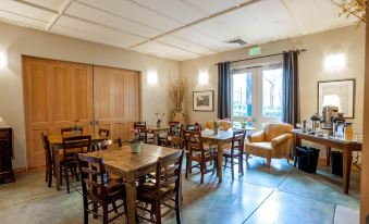 a large , well - lit room with wooden furniture and a couch near the window , creating a cozy atmosphere at Southbridge Napa Valley