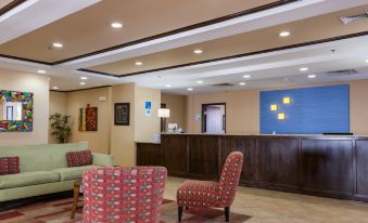 a modern hotel lobby with a reception desk , comfortable seating area , and a blue light source at Holiday Inn Express Newington - Hartford