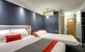 a hotel room with two beds , one on the left and one on the right side of the room at Holiday Inn Express Milton Keynes