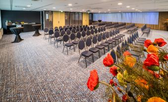 a conference room with rows of chairs arranged in a semicircle , ready for a meeting or presentation at Fletcher Wellness-Hotel Leiden