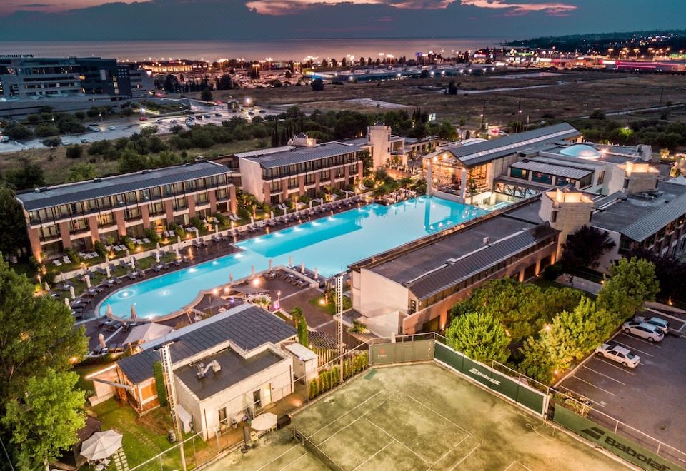 aerial view of a large hotel with a swimming pool , surrounded by buildings and other structures at Hotel Nikopolis