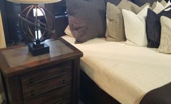 a bed with a brown headboard and white sheets is next to a wooden nightstand at RiverBend Lodge