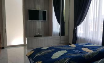 a modern bedroom with a blue and white patterned bedspread , wooden furniture , and a flat screen tv on the wall at Villa Orlando