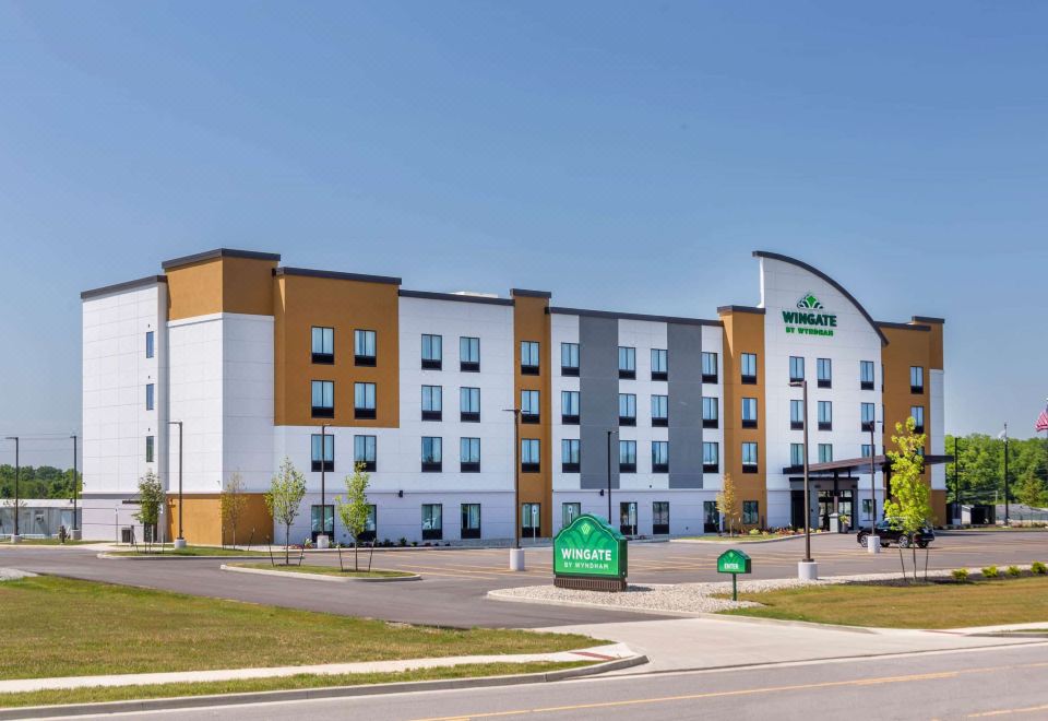a holiday inn express hotel with its green sign and the surrounding landscape in the background at Wingate by Wyndham Angola