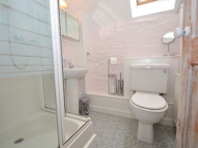 a bathroom with a white toilet , sink , and bathtub , along with a towel rack and window at Kim