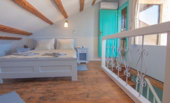 a bedroom with a bed , nightstand , and lamps is shown next to a blue door at Villa Mare