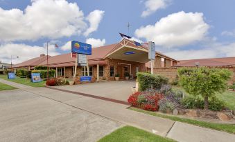 "a large brick building with a sign that reads "" comfort inn "" prominently displayed on the front of the building" at Parkes International