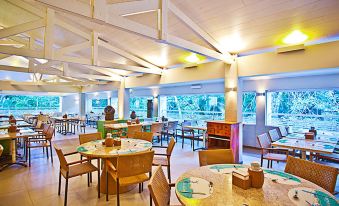 a large dining area with multiple tables and chairs , where people are enjoying a meal at Rio Quente Resorts - Hotel Pousada