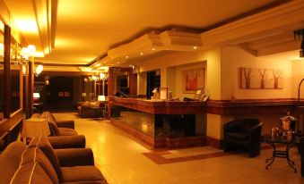 a hotel lobby with a reception desk , couches , and chairs arranged in a comfortable seating area at Hotel Frontera Clásico