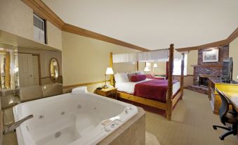 a luxurious hotel room with a jacuzzi tub , two beds , and a dining area , all decorated in a warm color scheme at Best Western Parkway Inn  Conference Centre