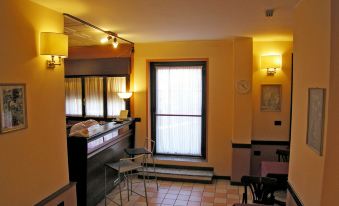 a hotel room with a bar , two chairs , and a window , illuminated by lights and sconces at Hotel Forum