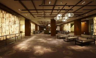 There is a spacious room with tables and chairs in the center, next to an arched door at Keio Plaza Hotel Tokyo