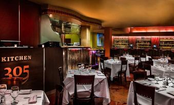 a well - lit restaurant with various dining tables and chairs , creating a pleasant atmosphere for patrons at Newport Beachside Hotel & Resort