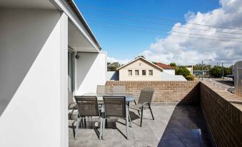 a patio with a dining table and chairs set up for outdoor dining , surrounded by a brick wall at Aspire Mayfield