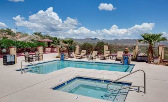 a large swimming pool with a hot tub and lounge chairs is surrounded by mountains at Dream Manor Inn
