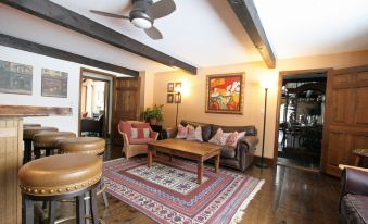 a living room with a wooden floor , a brown leather couch , and a rug on the floor at Old Saco Inn