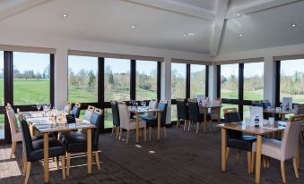 a dining room with tables and chairs arranged for a group of people to enjoy a meal together at Greetham Valley