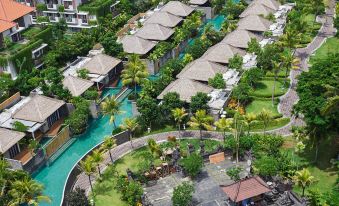 an aerial view of a resort with multiple buildings , a pool , and lush greenery surrounding it at Merusaka Nusa Dua