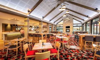 a large dining room with wooden tables and chairs arranged for a group of people to enjoy a meal together at Quest Wodonga