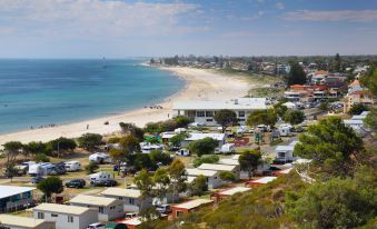 a beach town with a small town and a large body of water in the background at Brighton Beachfront Holiday Park Adelaide